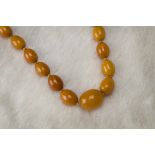 An Art Deco period amber bead necklace, having two rows of toffee and caramel coloured graduating