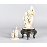 A Meiji period Japanese ivory okimono, modelled of father and son with parasol, Sotheby's sticker to