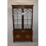 A Georgian-style glazed mahogany bookcase, with arcaded frieze above pair of glazed doors, above two