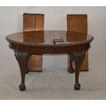 A 1920s carved mahogany oval wind-out dining table, with gadrooned edge, on cabriole ball and claw