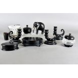 A collection of ebony items, including three cornucopia dwarf candlesticks, lidded pots etc, plus