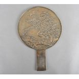 A late Meiji period Japanese bronze mirror, with decorative back of canes in blossoming tree,