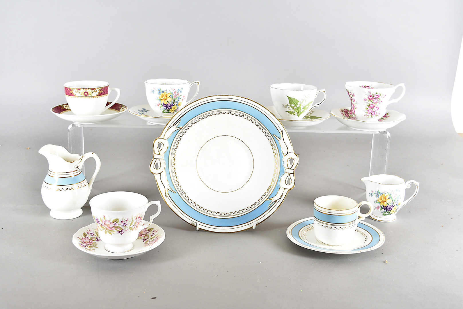 A collection of Staffordshire trios, all with transfer printed floral decoration including a Queen