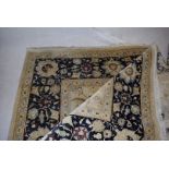 A large Pakistani hand-made woollen carpet, with overall floral detail, blue border and cream