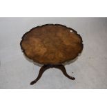 A circular tilt top table, Figured walnut with pie crust edge on splayed supports, 49cm high 60 cm
