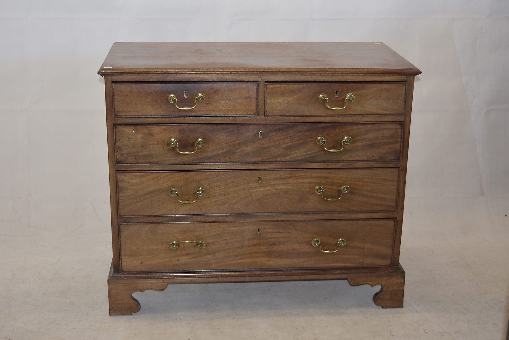 An early 19th Century mahogany chest of drawers, three long and two short graduated drawers, brass
