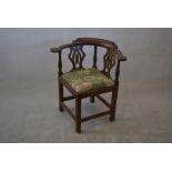A George III oak and elm corner chair, with pierced back splats and upholstered seat, on stretchered
