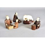 Three Meiji period Japanese box wood and ivory figures, modelled seated at work, together with a