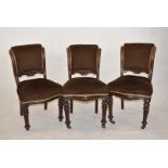 Three Victorian chairs, upholstered in a brown fabric, with shaped legs to front and sabre legs to