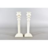 A pair of 19th Century ivory turned candlesticks, of tapered design, on rectangular stepped base, 22