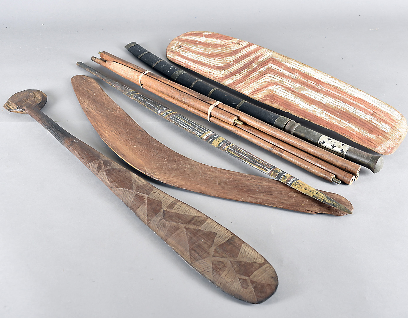 A collection of Aboriginal carved wooden hunting and ceremonial items, including a painted spear and