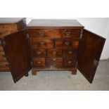 A mahogany two door cupboard, the doors open to reveal numerous drawers to inside, of various sizes,