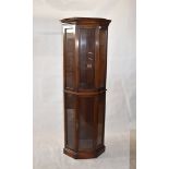 A reproduction mahogany glazed corner display cabinet, two-tier, two glazed doors, on plinth
