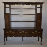 A 19th Century and later oak farmhouse dresser, with open rack and flanking cupboards, above base