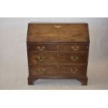 A George III mahogany 'farmhouse' bureau, with fall front with decorative brass escutcheon, fitted