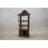 A small 1900s mahogany bookcase, having three tiers, shaped top, with lower two door cupboard, on