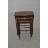 An Edwardian set of three mahogany Sheraton-style nesting tables, with satinwood stringing and one