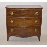An early 19th Century mahogany bow-front chest of drawers, three long graduated drawers, with oval