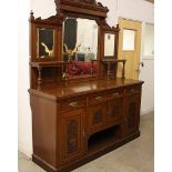 A large Edwardian oak sideboard, the base fitted with three frieze drawers above four carved panel