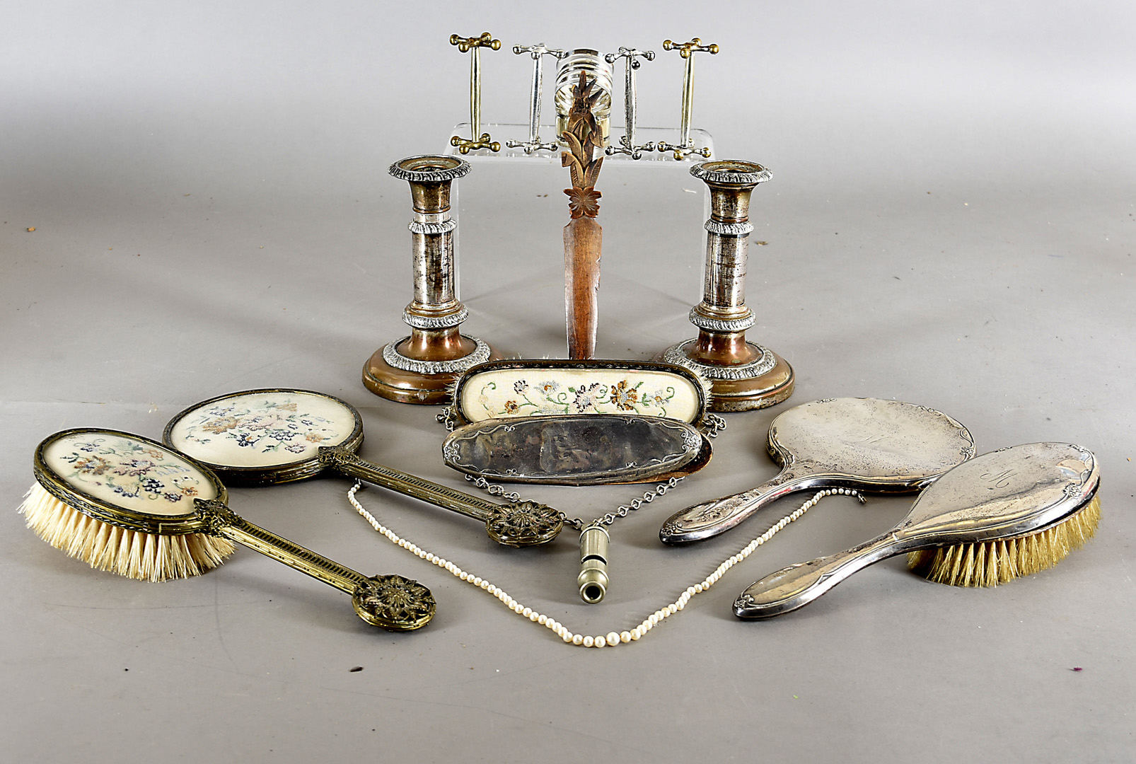 A pair of telescopic silver plated candlesticks, a part silver dressing table set, a string of