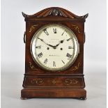 A William IV mahogany eight day mantel clock, with brass inlay, domed top with carved arch inlaid