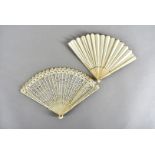 A 19th Century bone brise fan, with pierced decorative design, held with silk ribbon and pink