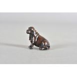 A Japanese hardwood netsuke, carved as a long eared spaniel with black glass eyes, 5 cm