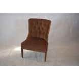 A reproduction button-back nursing chair, tan fabric, tapered supports, 36cm high x 66cm wide x 58cm