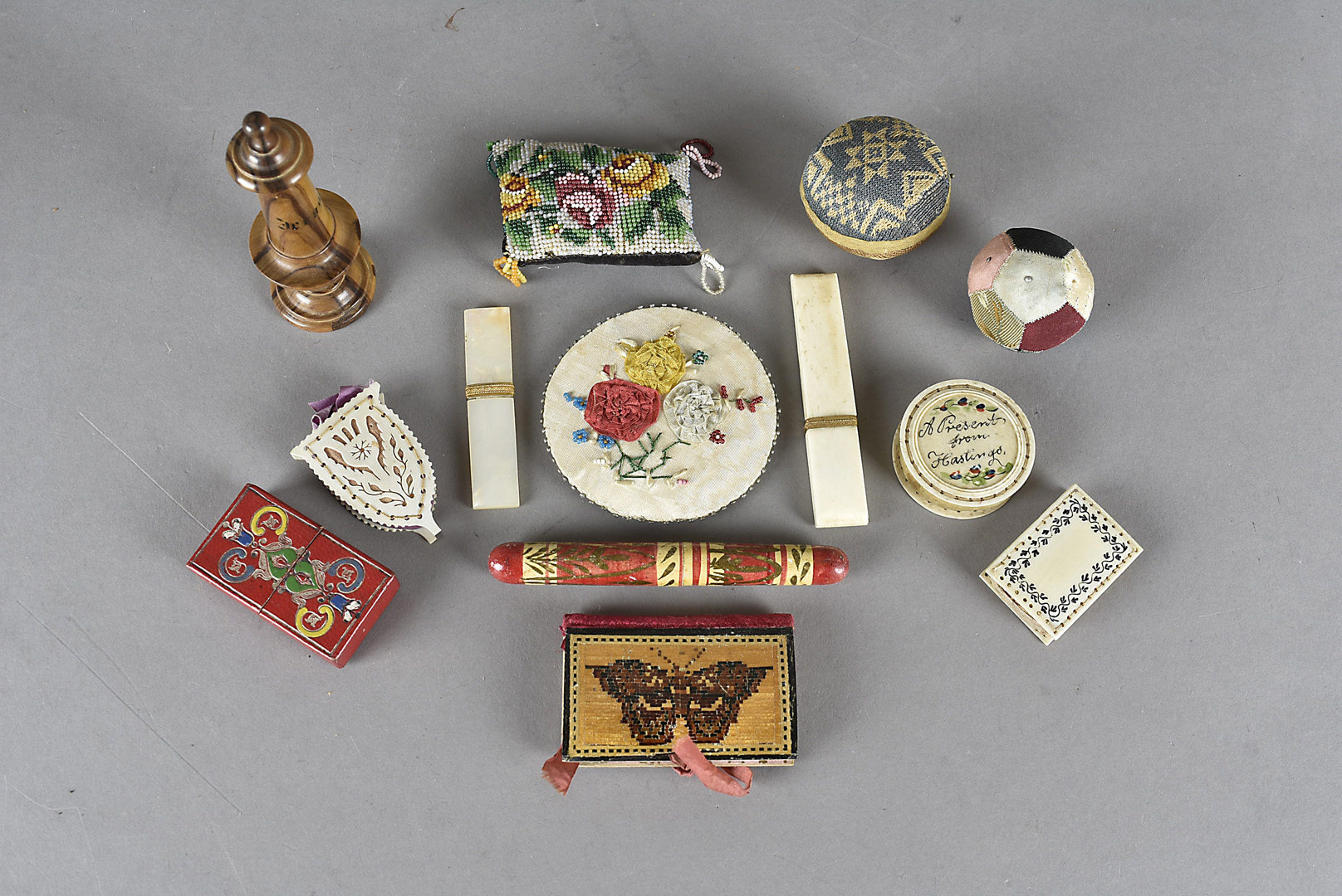 A collection of 19th Century needle cases and pin cushions, comprising three bone cased pin
