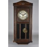 An oak cased wall clock, having eight day movement with chime, strikes on a gong