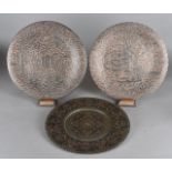 A pair of Middle Eastern copper and silver chargers, having symbolic decoration, 32.5 cm diameter,