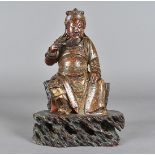 A 19th century Chinese soapstone carved figure, modelled as a seated warrior, stroking his beard,