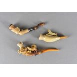 Three Meerschaum and amber cheroot holders, all carved with decorative scenes, one of a wild