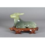 A Jade carving of a water buffalo, modelled reclining on a hardwood stand, in a fitted silk lined