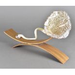 A modern mottled glass and bentwood sculpture, the blown glass in a floral shape supported on a