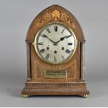 An Edwardian oak and inlaid eight day mantel clock, of arched form with steel face and roman