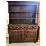 A late 18th Century oak Welsh dresser, having two lower cupboards with three drawers, above two