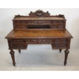 A Victorian oak carved desk, with raised upper section fitted with drawers and carved mask
