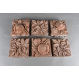 A collection of sixteen arts and crafts terracotta wall tiles, decorated in relief, seven with