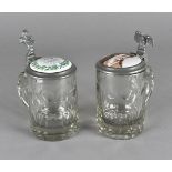 Two German glass, pewter and porcelain lidded beer tankards, one with spread eagle thumb rest and