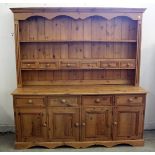 A pine Welsh dresser, having four drawers and doors to base, with six smaller drawers and shelf to