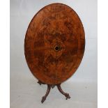 A Victorian walnut inlaid loo table, oval top with central decoration, on a four column base, on