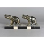 An Art Deco spelter figure group, modelled as a pair of elephants, with raised trunks, on an onyx