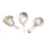 A group of three George III and later silver tea caddy spoons, each with shell shaped bowls, one