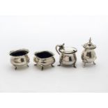 Four George V silver cruet items, including two trench salts with blue glass liners, a mustard
