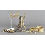 A collection of beads and charms, including a snake vertebrae, three late 19th Century ivory