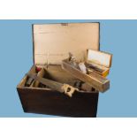 A large wooden carpenters tool box, with steel banded top and side carry handles, containing a