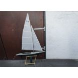 A fibreglass remote control sailing boat, "Waylander", having green and white hull, on stand, marked