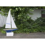 A large 1970s remote control pond yacht, "Basil", having blue fibreglass hull and wooden deck, on