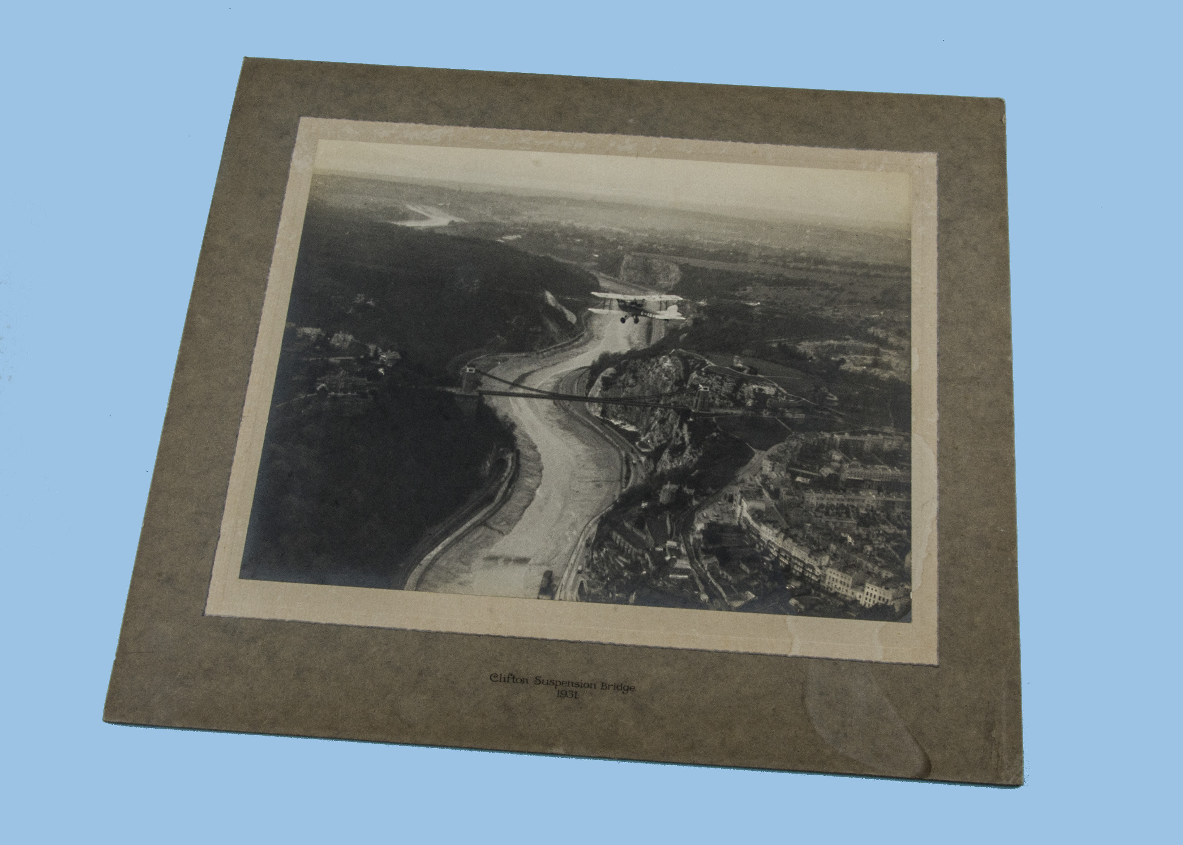 A 1930s silver gelatin photograph, airside image of a Tiger Moth or similar biplane flying over